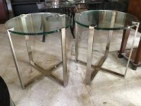 Both round glass and chrome side tables side by side on floor