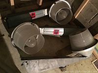 Three industrial style lights laid on the floor, showing the metal bodies and glass globes. The globes are large, frosted, and approximately 14 inches in diameter. The metal arms are about 33 inches long.