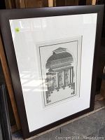 Full view of the framed black and white architectural print leaning against wooden surface showing frame condition.