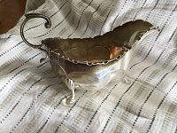 Side angle view showing the scalloped rim, curved handle, and overall shape on a draped cloth background.