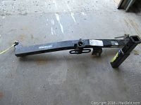 Full view of the Draw-Tite trailer hitch laid on concrete with visible mounting parts and a square receiver tube.