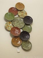 Full view of the wall art showing the plate cluster mounted vertically against a wall.