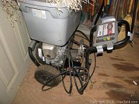 Simpson pressure washer showing overall unit with metal frame, large tire and connected hose in storage setting.