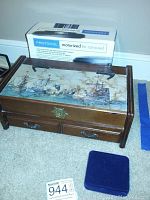 Wooden box with painted nautical ships on lid with a box on top.