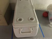 End view of white Coleman cooler with handle visible