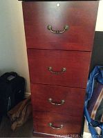 Front view of the wood filing cabinet showing four drawers with metal handles.