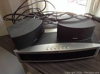 Front view showing media console and two satellite speakers on top