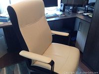 Front angle view of cream color Malcolm office chair with padded armrests and black base.
