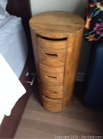 Front view of one night stand showing cylindrical shape and four curved drawers