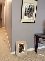 Photo of the smaller unframed photo leaning against a wall near a staircase