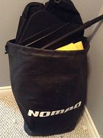 Black Nomad carrying case standing upright with paddle handles and folded kayak visible