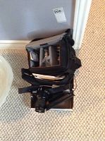 Photo of camera and carrying case with compartments showing film, manuals, and accessories inside.