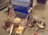 Overview photo of entire kitchen lot showing Rubbermaid containers, pots, pans, steamer, knife block with knives and other items.