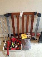 Overall view of the wooden and metal dog gate with a box containing Ruffwear dog harness and another Ruffwear item in packaging placed in front.