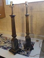 Pair of vintage Italian lamps with black marble bases and bronze fluted columns shown on table.