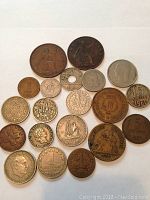 Photo of various vintage coins arranged with larger coins at the top and smaller at the bottom