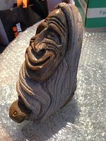 Three-quarter front view of carved soapstone figurine showing character face and hair details