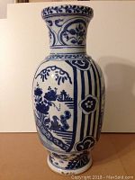 Front view of Chinese blue and white porcelain vase showing floral and landscape motifs in cobalt blue on white porcelain.