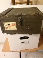 Closed vintage wooden munitions box with military sticker on front