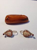 Top view of earrings and amber pin showing cameo front details and red stones on earrings