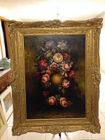 Full front view of oil painting in an ornate gilded frame showing floral still life