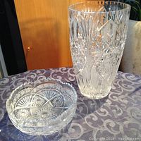 Photo showing the Bohemia lead crystal tall vase and bowl on a patterned surface with visible intricate cuts and patterns.