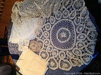 Six hand-knit crochet centerpieces laid out on a dark surface showing various sizes and patterns.