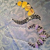 Two necklaces laid out, showing the different stone types and linked chains.