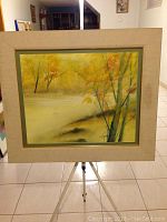 Full view of framed watercolor painting on easel