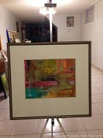 Full view of the framed watercolor painting showing the abstract composition and colors.