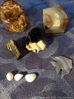 Overview of all stones and minerals, three opal stones, quartz rock, other mineral specimens including a carved bird-shaped polished mineral