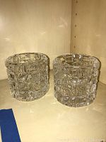 Two clear crystal rock glasses with textured cube pattern sitting on a shelf.
