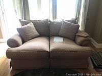 Front view of Thomasville loveseat showing seat cushions, back cushions, two throw pillows, and rolled arms with arm covers.