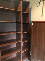 Full view of IKEA narrow bookcase with six shelves, showing upright structure and wood finish.