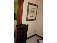 Dark wood display case with multiple compartments placed under floral print