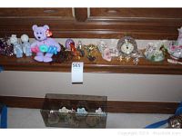 Wide shot showing the whole decorative lot arrayed on a wooden ledge and a glass shelf below with floral napkin rings.