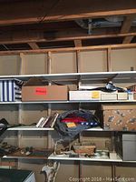 Shelving unit with multiple cardboard boxes and bags, some marked and containing sports cards
