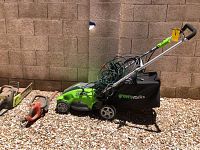 GreenWorks electric lawnmower with grass catcher bag and cord, overall view.