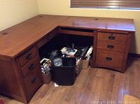 Full view of the L shaped desk showing drawers, keyboard tray, and cabinet with faux drawer front, placed in corner room.