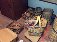 Multiple woven Longaberger baskets of various shapes including membership and lid baskets