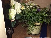 Photo of artificial white roses and greenery arrangement in vase/pot