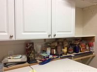 Overall view of candles, bookends, picture frames, and various home decor items on a shelf.