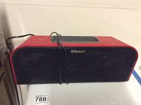 Front view of the rectangular red Bluetooth speaker with a black grille and Klipsch branding in the center.