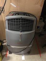 Front view of cooler showing vent grille, caster wheels and overall unit