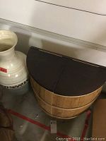 Front view of white plastic vase and the half circle barrel storage unit with visible top lids