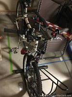Front view of white Specialized Rockhopper mountain bike on bike stand showing handlebars, front tire, and pedals.