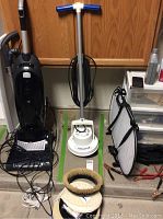 Full view of Orbiter machine standing on garage floor with power cord wrapped around handle, adjacent items not included