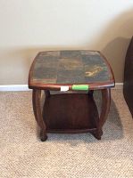 Front view of a brown tile end table with a tiled top made of slate-like stone tiles in a grid pattern. Shows scratches and marks on the wood frame.