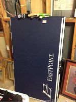 Folded blue EastPoint ping pong table with logo visible.