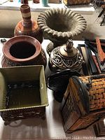 Photo showing a top view including large ceramic vases, square basket with liner, and woven wine case